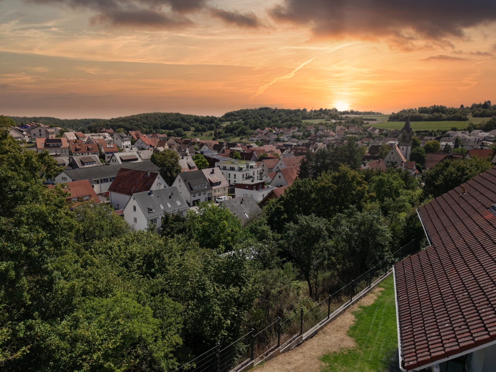 Drohnenaufnahme in der Goldenen Stunde über ein Dorf